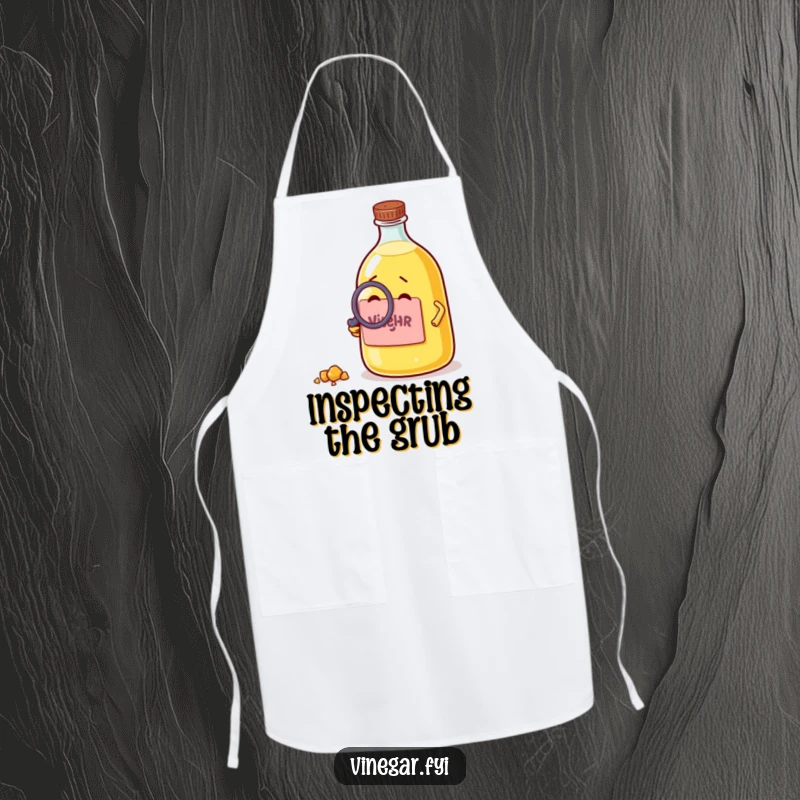 Funny apron with a curious vinegar bottle using a magnifying glass to examine a crumb, merging kitchen protection with humor.